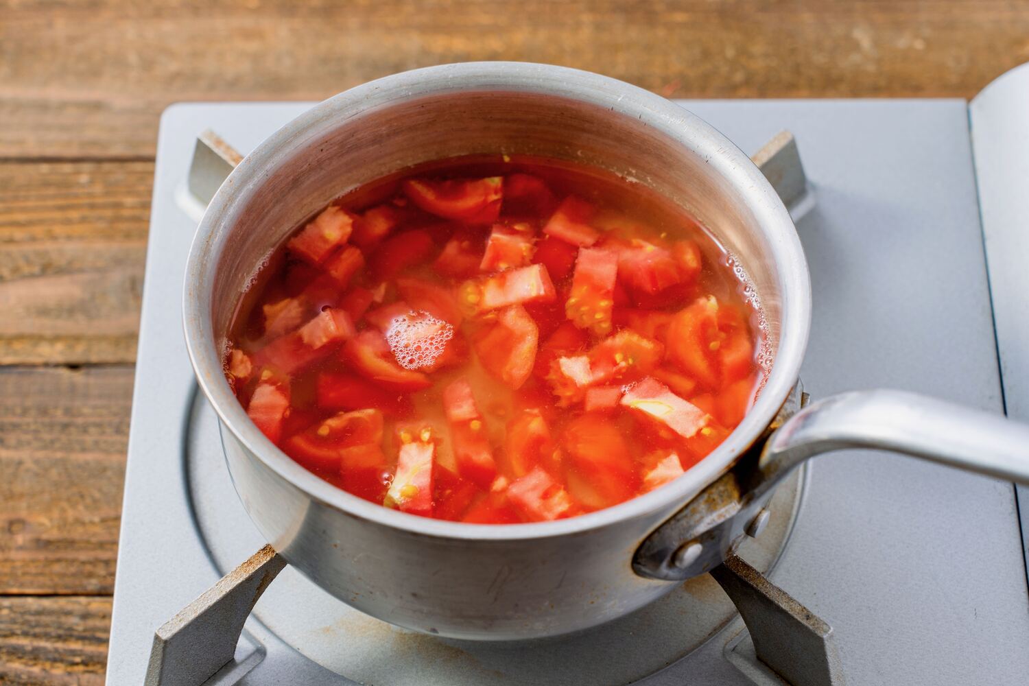 小鍋で角切りトマトを煮る