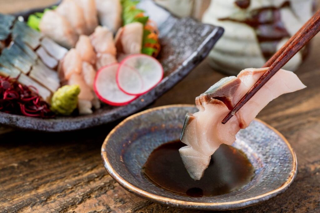 北海道産寒サバの刺身を醤油につけて食べる