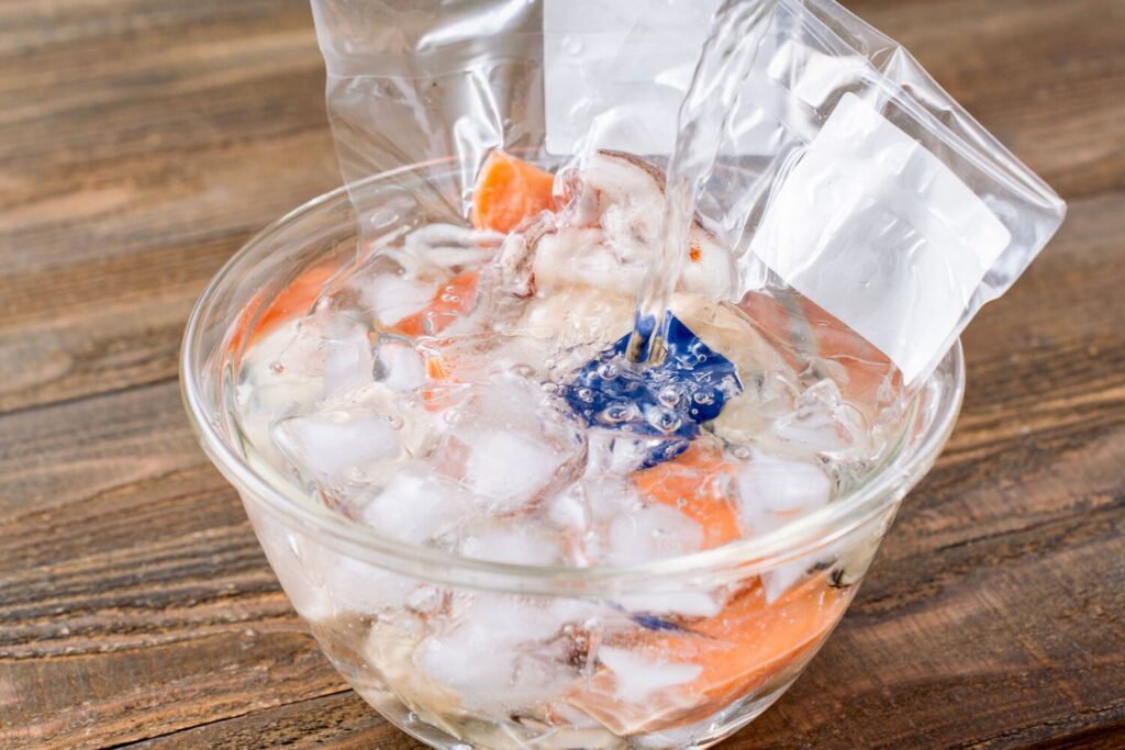 3D凍結されたマルホン小西漁業のシーフードミックスを氷を張った冷水で解凍する